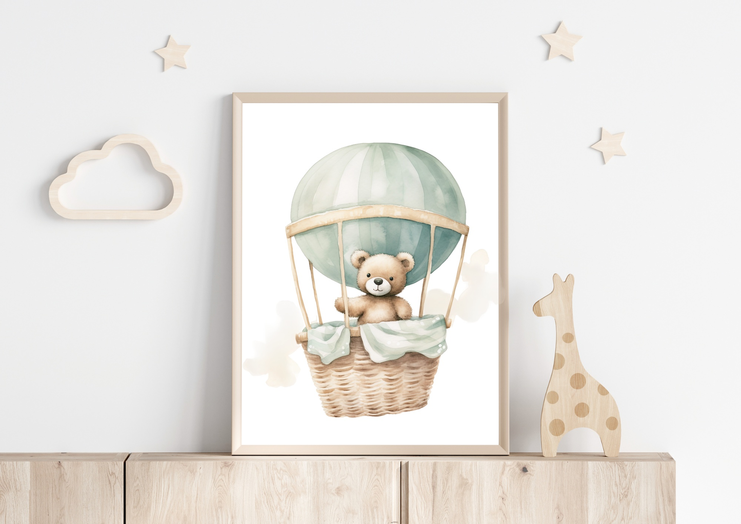 Baby room poster with a teddy bear in a hot air balloon, framed and displayed on a shelf with wooden cloud and star decorations.