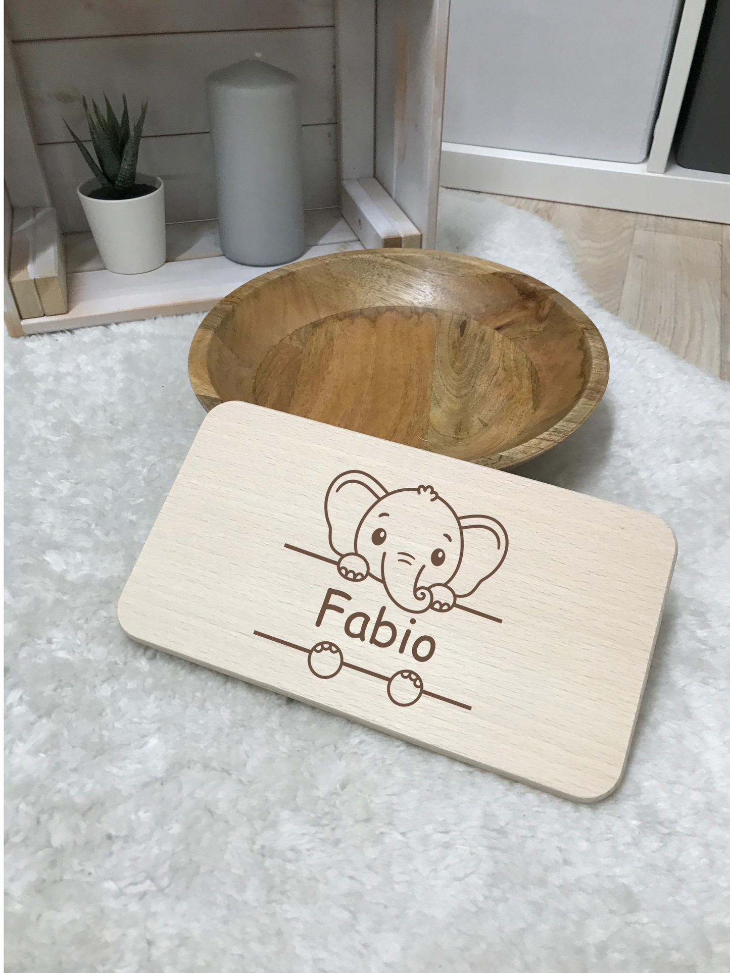 Hochwertiges Frühstücksbrettchen aus Birkenholz mit individuellem Design neben einer Holzschale.