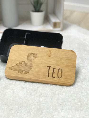 Personalized dinosaur lunchbox with bamboo lid and black plastic base.