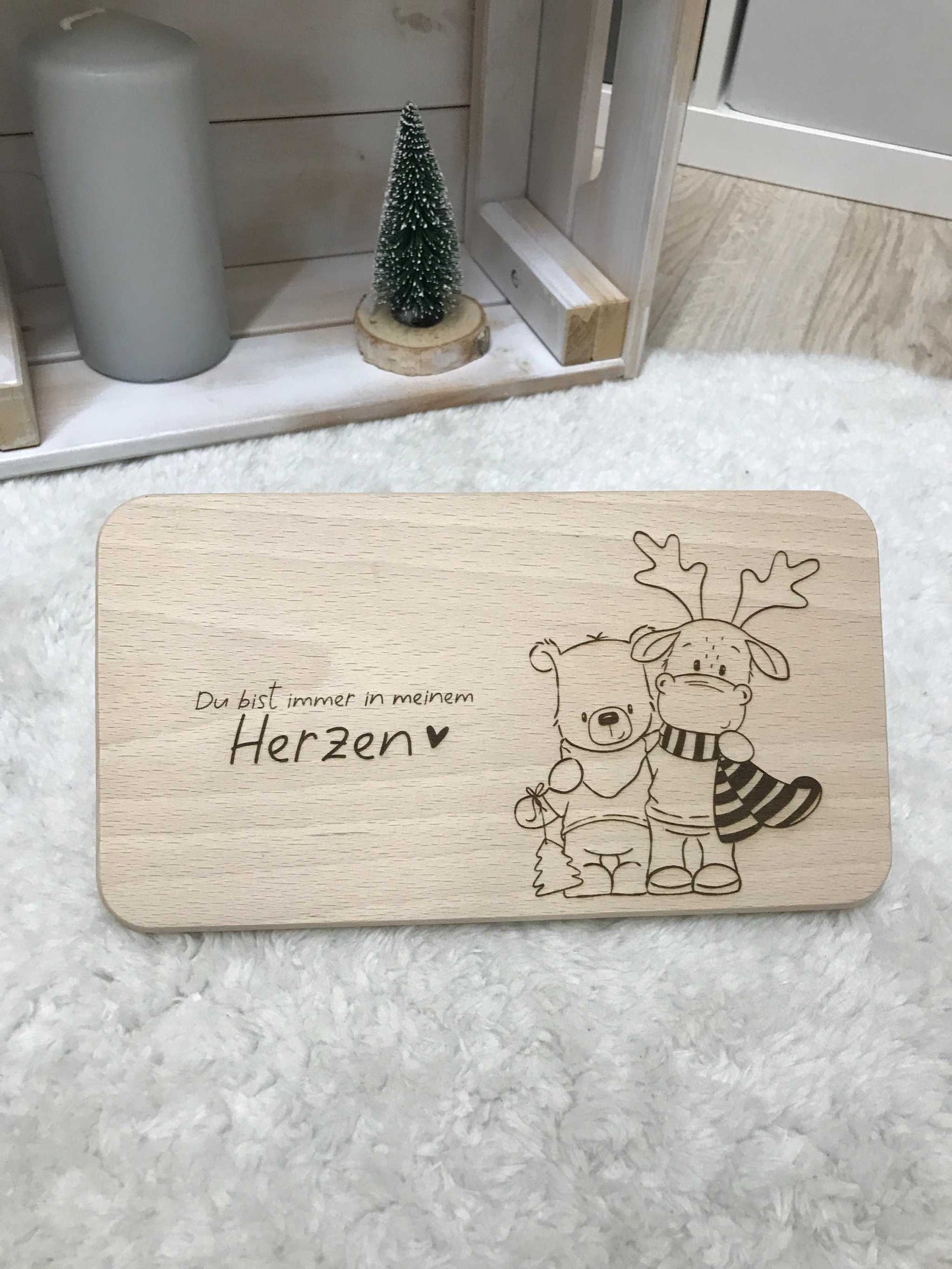 Hochwertiges Holz-Frühstücksbrettchen mit niedlichem Gravurdesign auf Teppich.