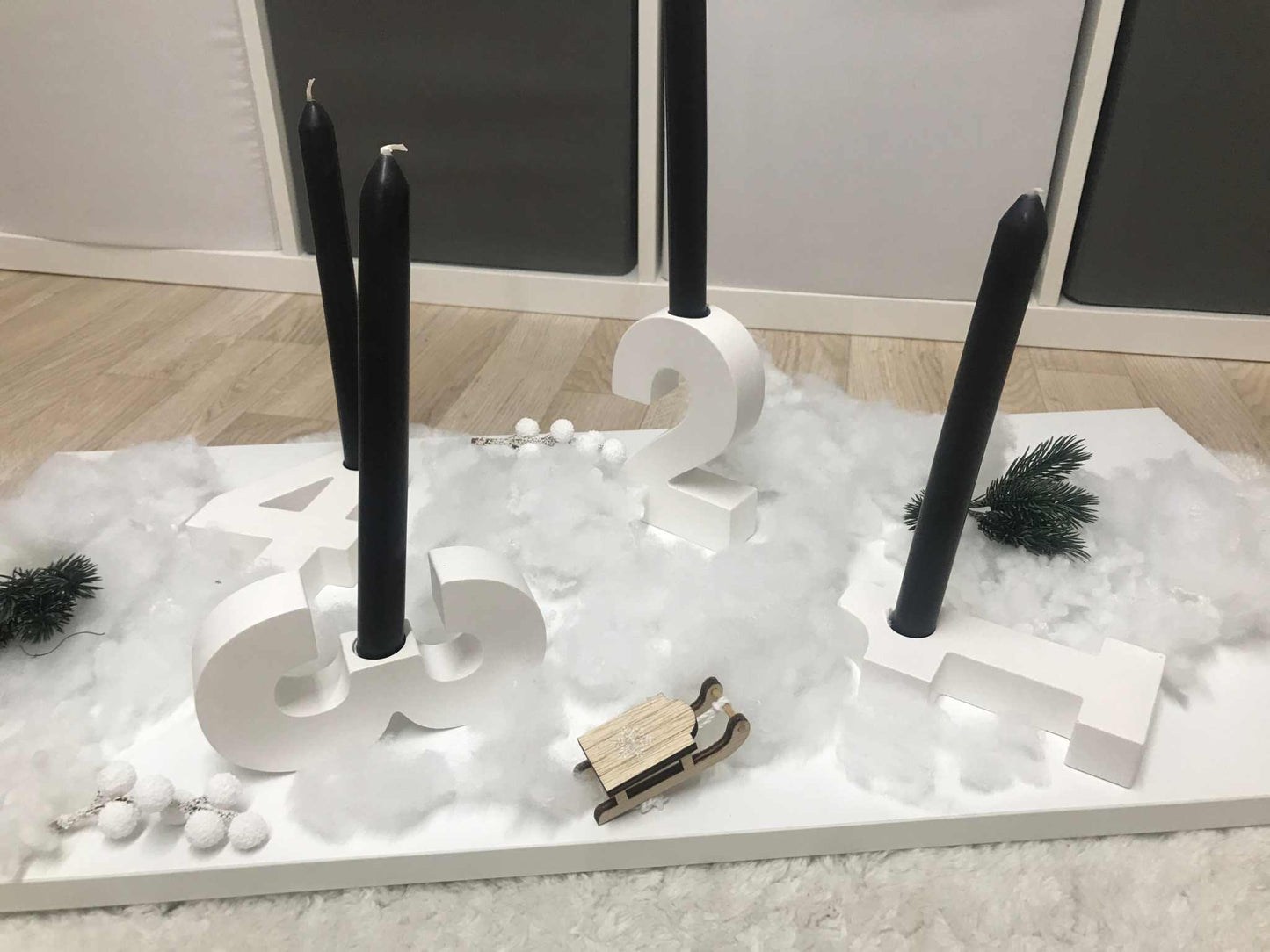 Minimalistischer Adventskranz aus weißem Raysin mit Zahlenkerzenhaltern für Adventssonntage.