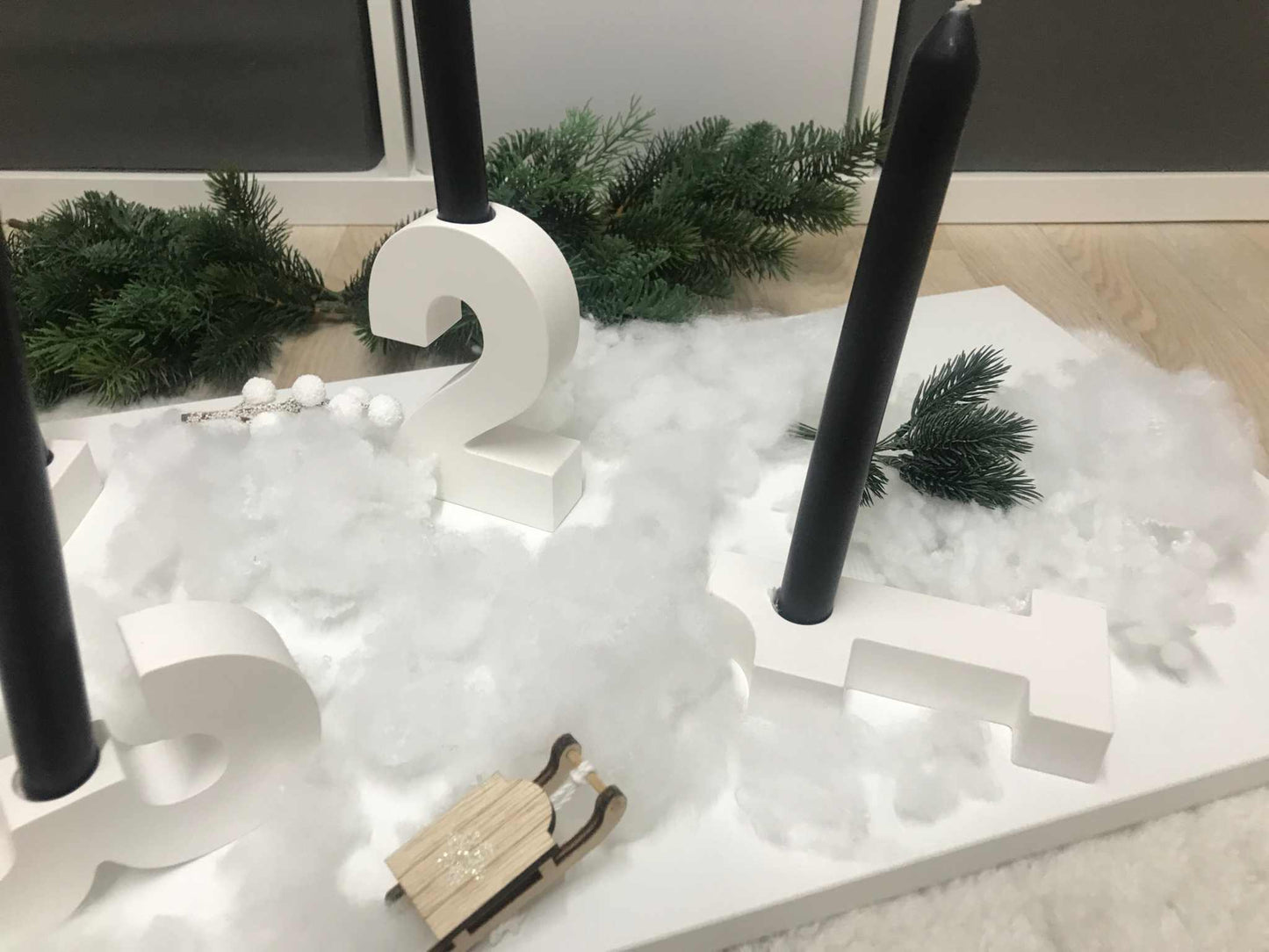 Minimalistischer Adventskranz aus weißen Raysin-Zahlen als Kerzenhalter für Stabkerzen.