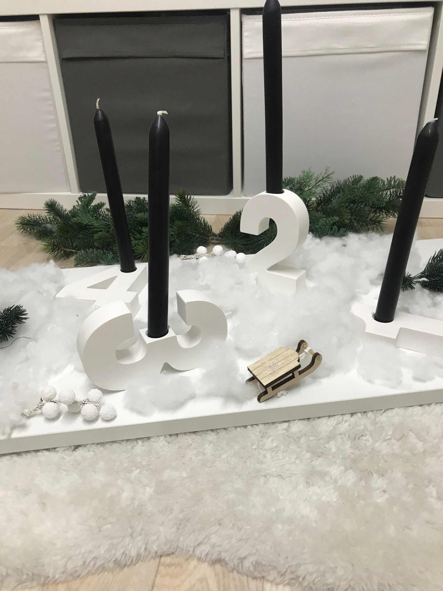 Minimalistischer Adventskranz aus weißem Raysin mit nummerierten Kerzenhaltern für Stabkerzen.