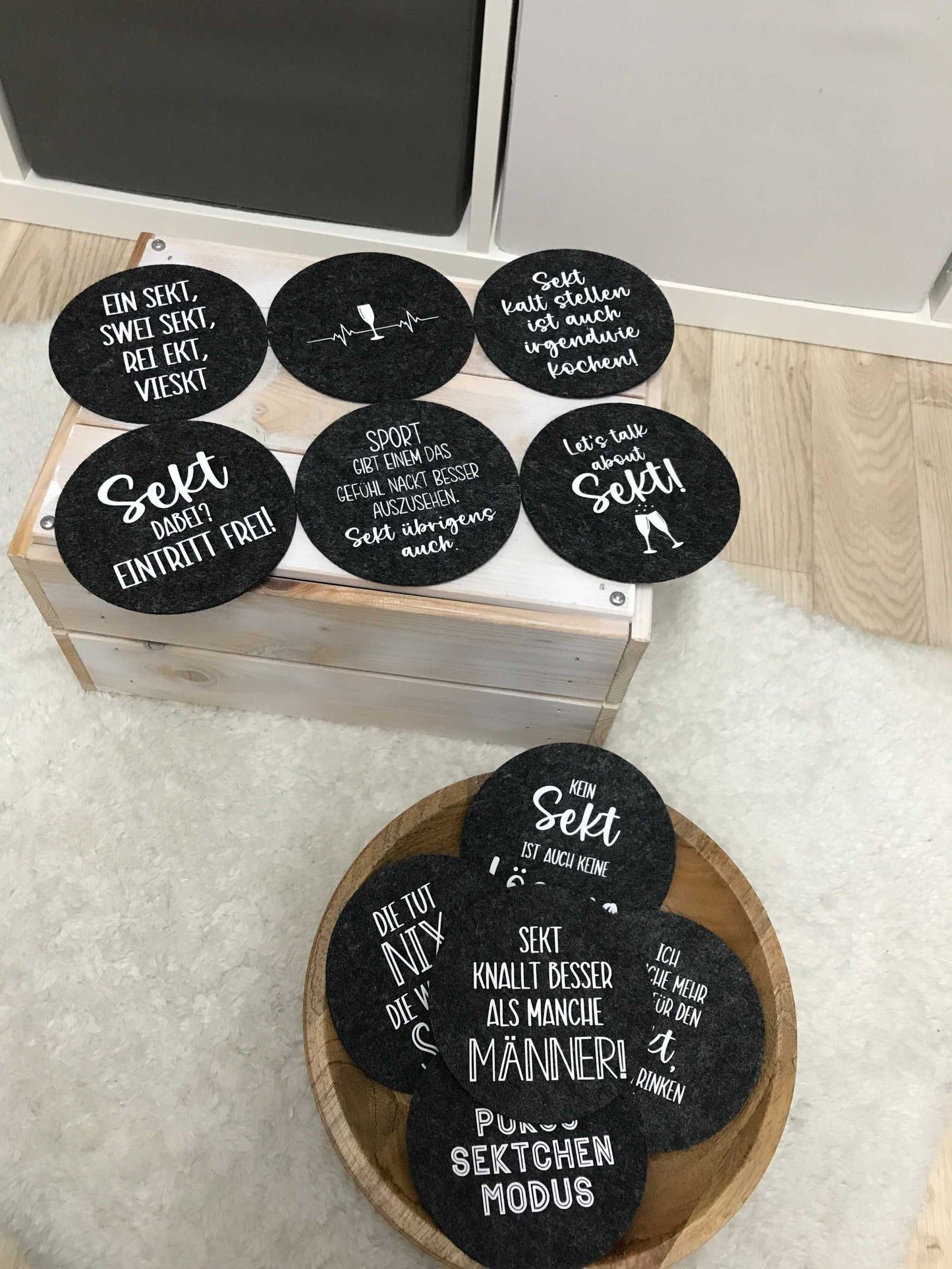 Runde Filzuntersetzer mit Sektsprüchen, anthrazitfarbene und hellgraue Varianten, ideales Geschenk für Mädelsabend.