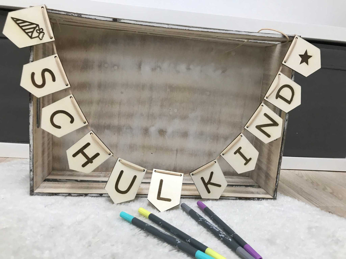 Wimpelkette aus Holz zur Einschulung mit personalisierten Buchstaben und Dekorsymbolen auf Lederband