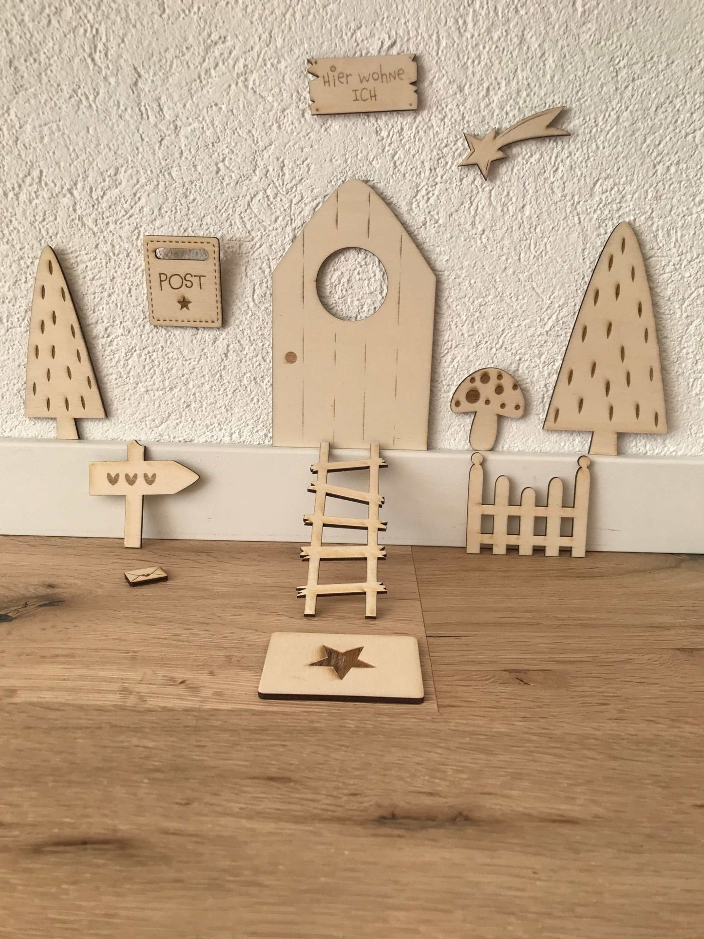 Holz-Wichteltür mit Zubehör für stilvolle Weihnachtsdekoration aufgestellt vor einer Wand.