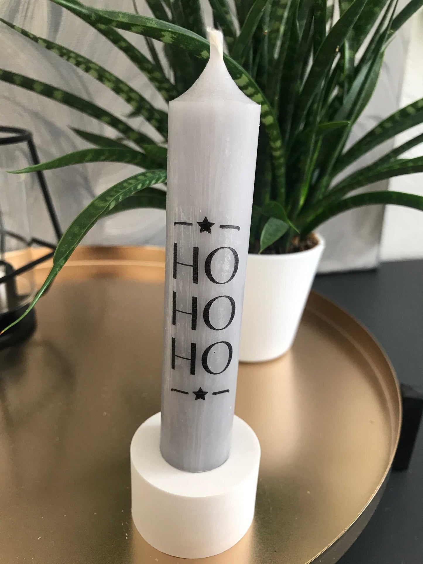 Festliche Stabkerzen in Grau mit "HO HO HO" Design auf weißem Kerzenhalter, geeignet für Weihnachtsdekoration.