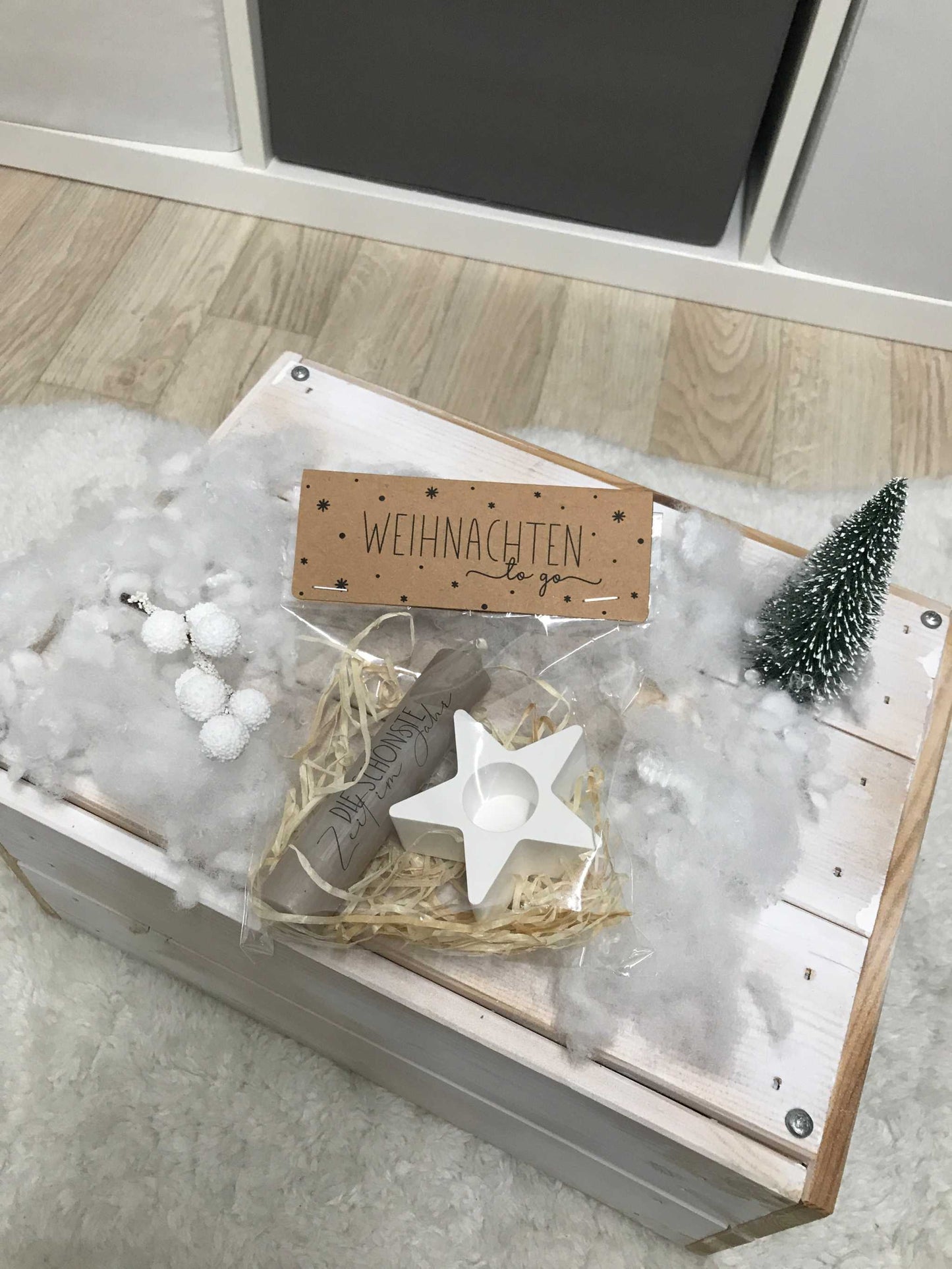 Weihnachtsgeschenk Kerze Geschenkset mit Kerzenständer, Stern und Karte auf dekorativer Unterlage.