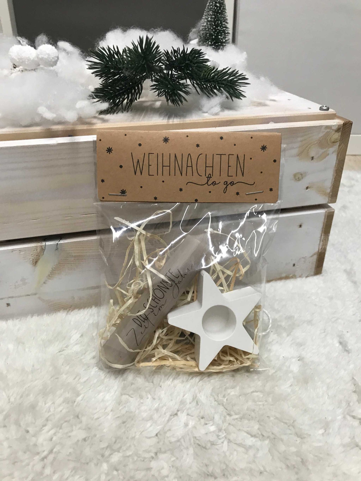 Weihnachtsgeschenkset mit Kerzenschmuck, Sternenhalter und Geschenkverpackung auf weihnachtlichem Hintergrund.