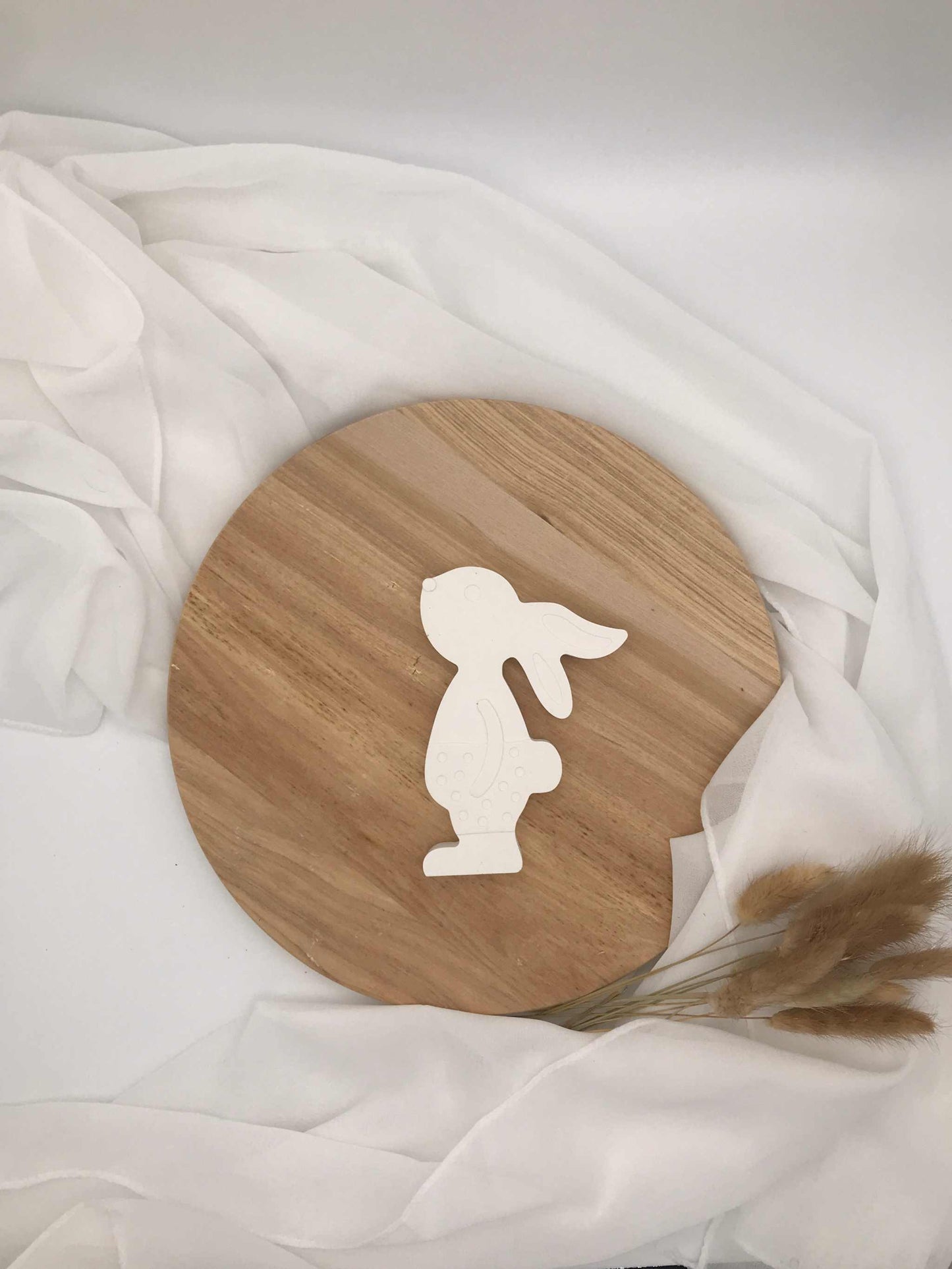 Osterhase-Aufsteller aus Raysin auf rundem Holzteller, Osterdekoration.