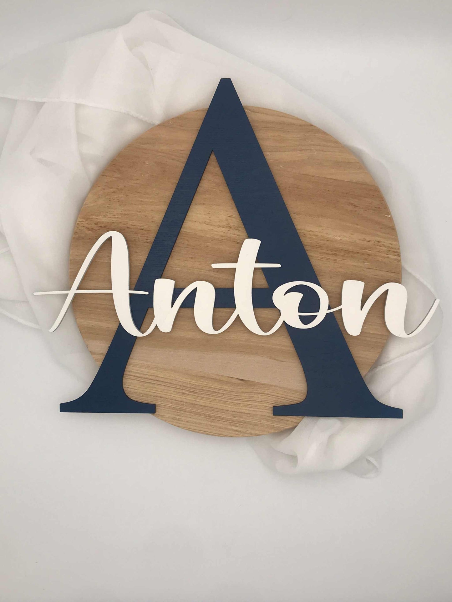 Türschild Kinderzimmer mit personalisiertem Namen, blauem Buchstaben und natürlichem Holz.