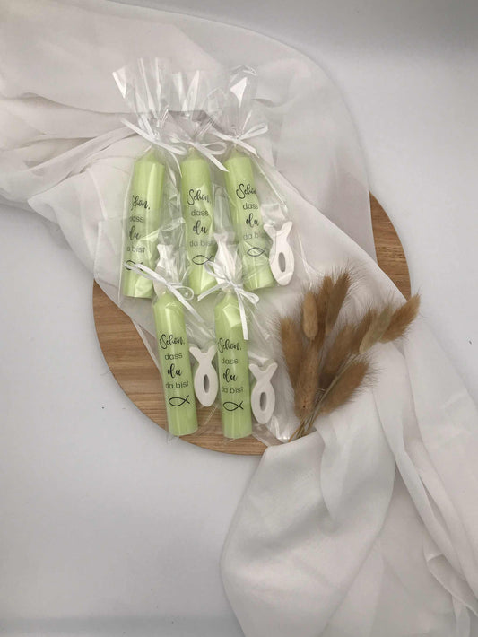 Handcrafted candles wrapped in clear packaging with symbolic fish decorations, designed as meaningful gift favors for religious occasions.