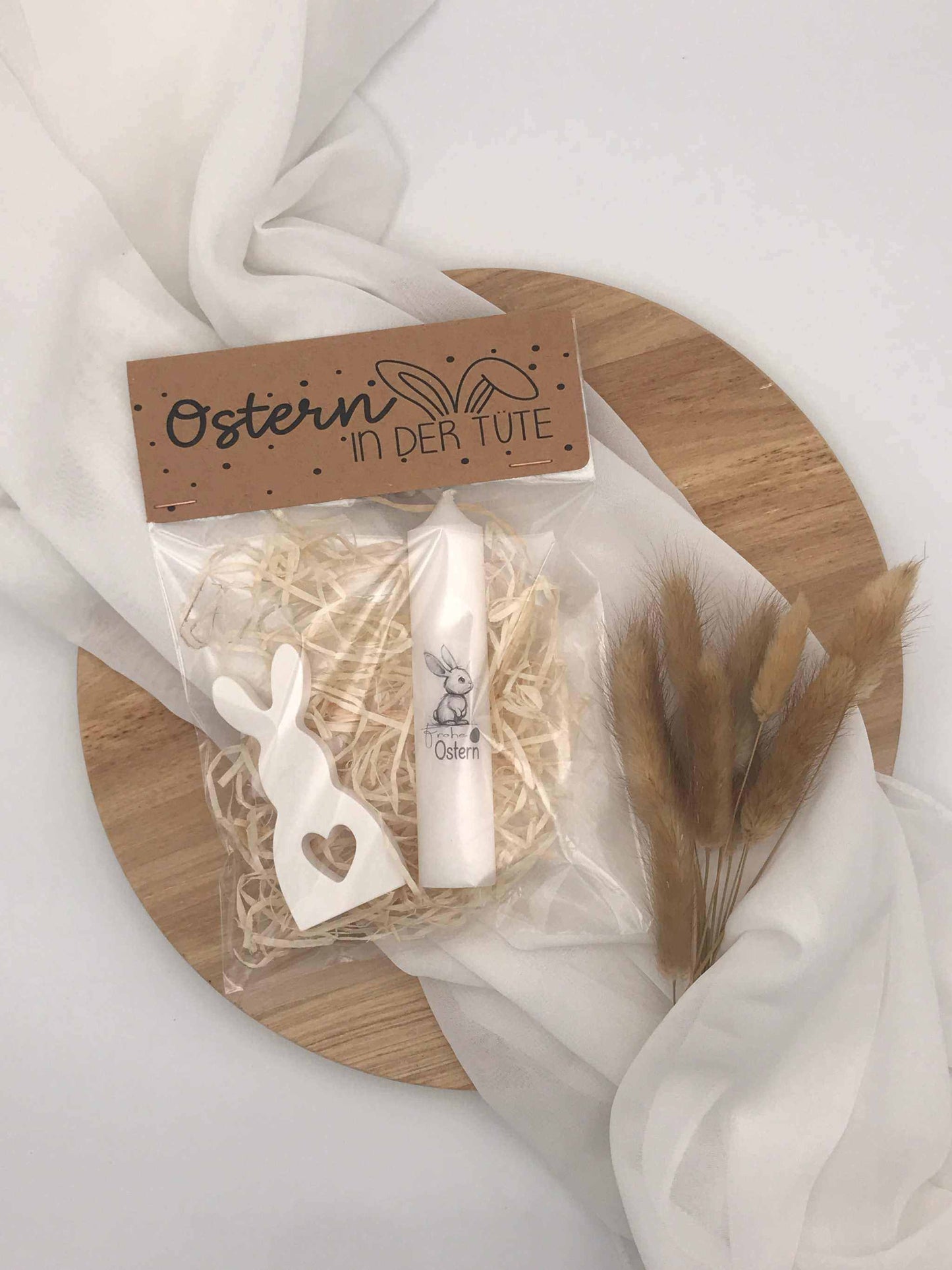 Easter gift set with handmade rabbit figurine and candle on decorative wooden tray.