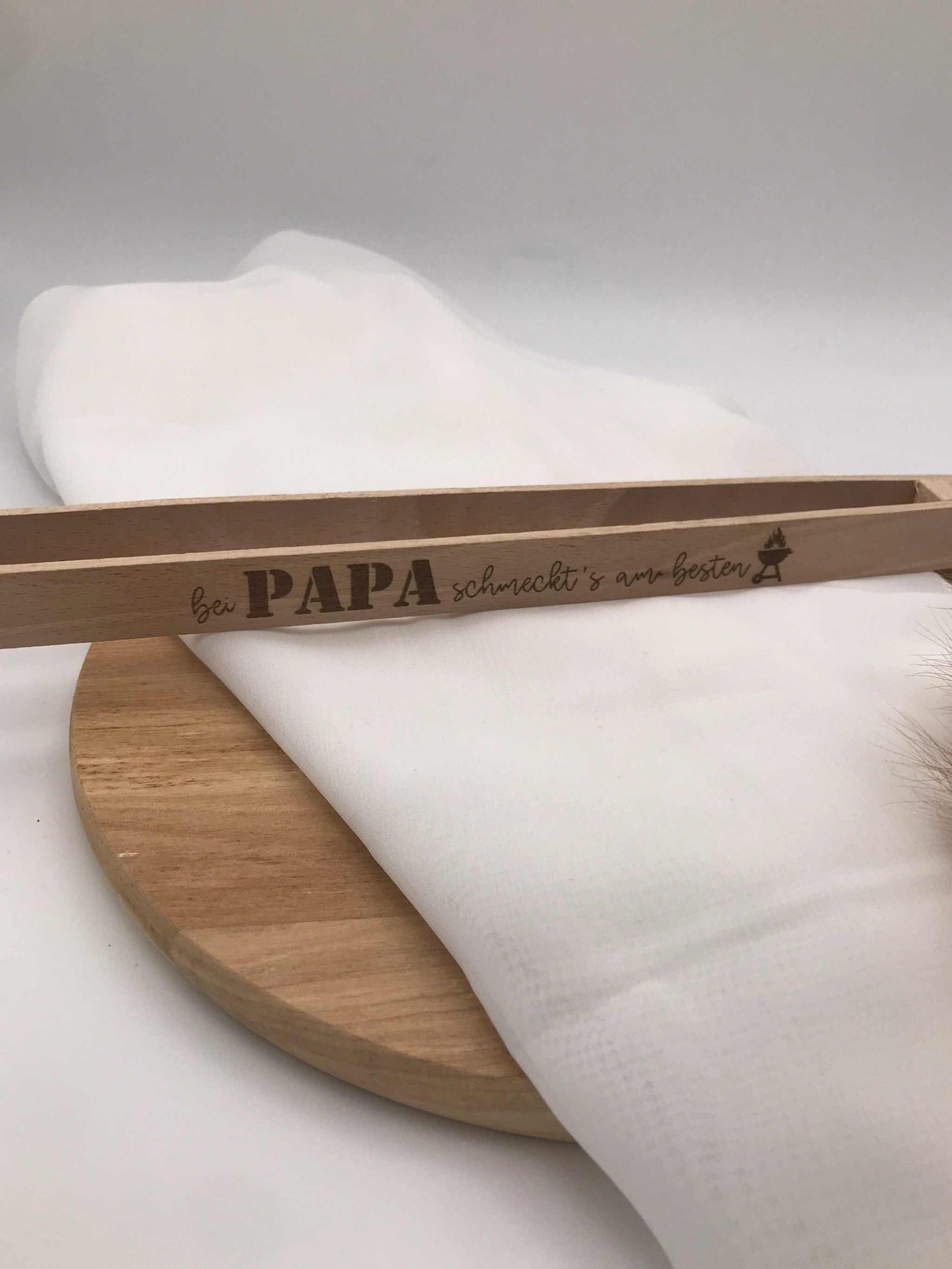 Grillzange aus Holz mit Flaschenöffner und Grillspruch "Bei Papa schmeckt's am besten" als BBQ Geschenk