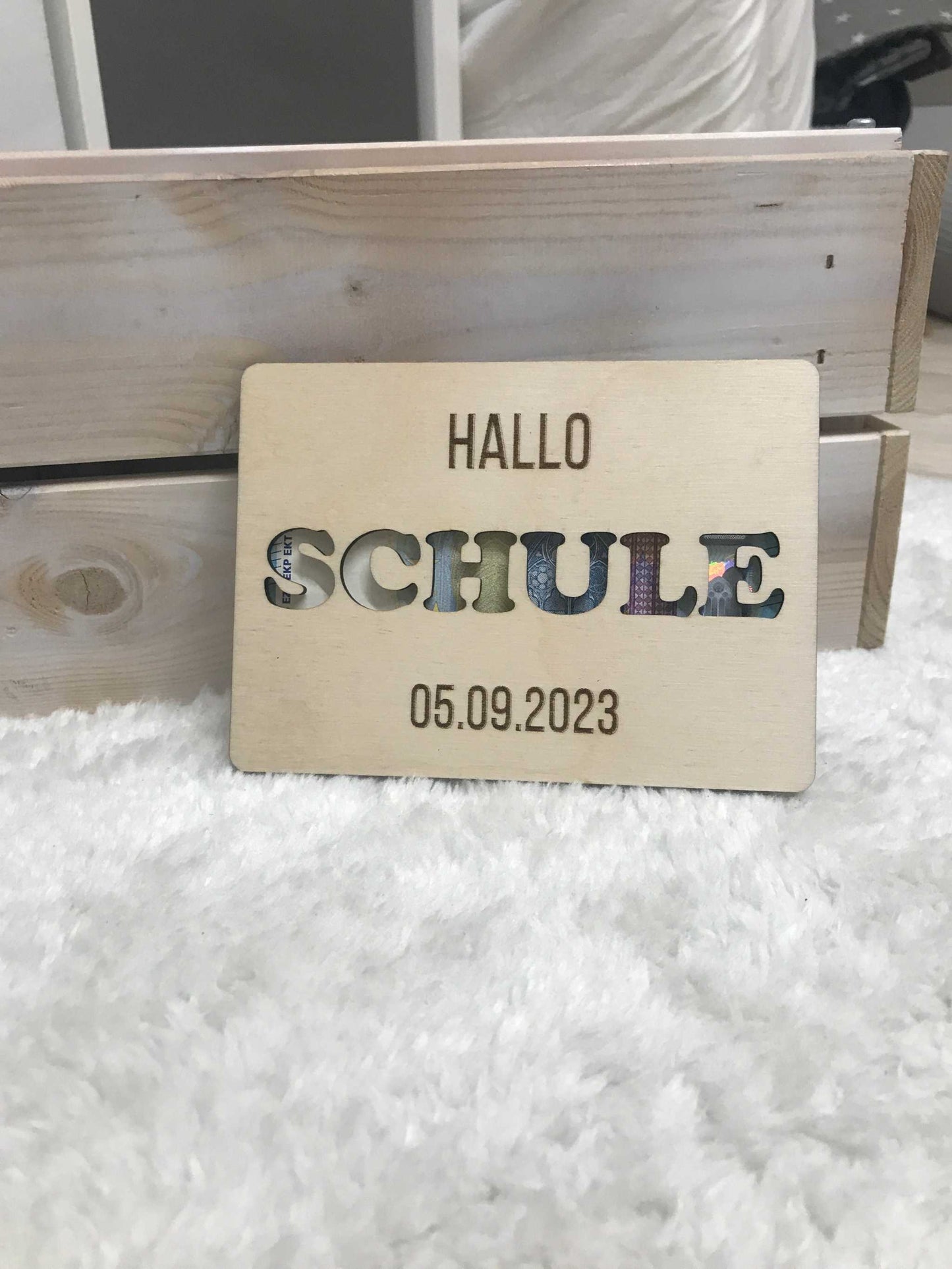 Geldgeschenk zur Einschulung mit "Hallo Schule" Gravur, Datum und dekorativem Design.