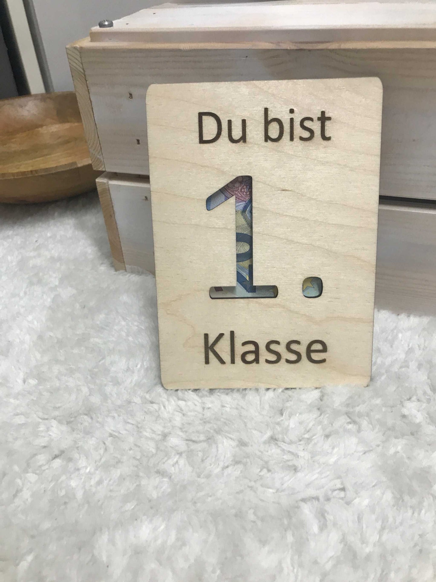 Geldgeschenk zur Einschulung mit Gravur "Du bist 1. Klasse" auf Holzplatte.