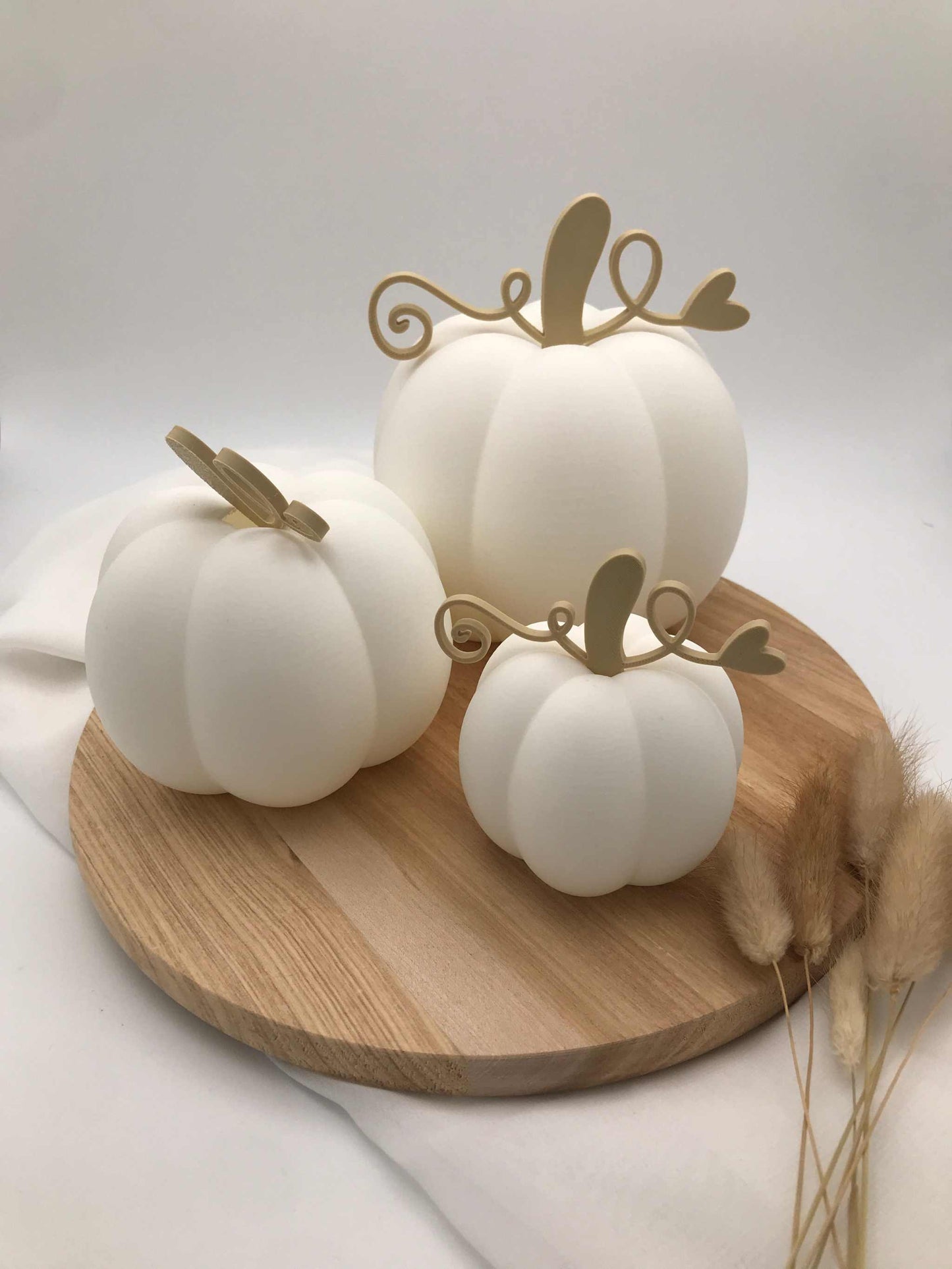 weiße Dekokürbisse aus PLA 3D-Druck in drei Größen mit goldfarbenen Stielen auf Holztablett, Herbstdekoration ohne Beleuchtung