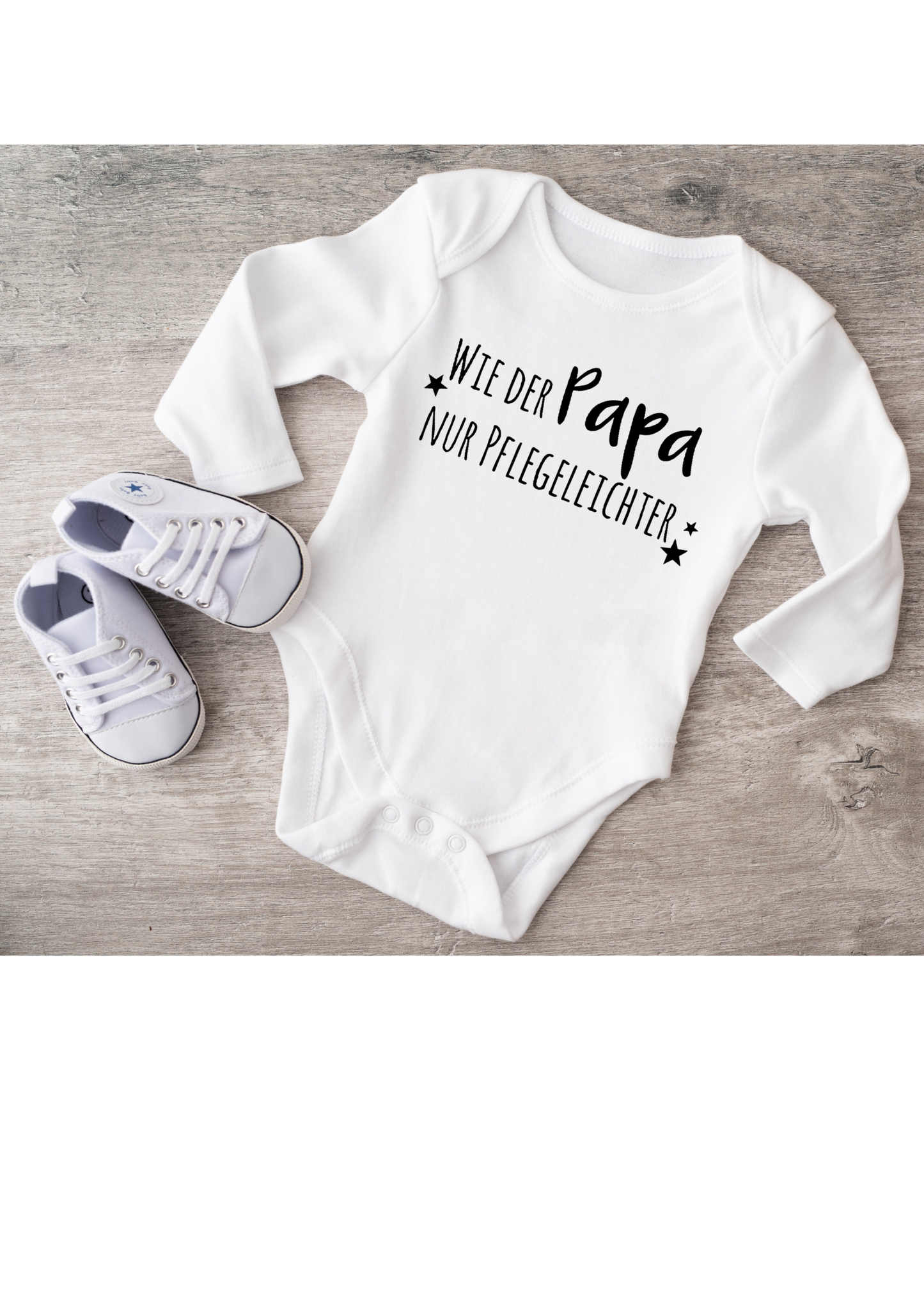 White baby bodysuit with text design, paired with white baby shoes.