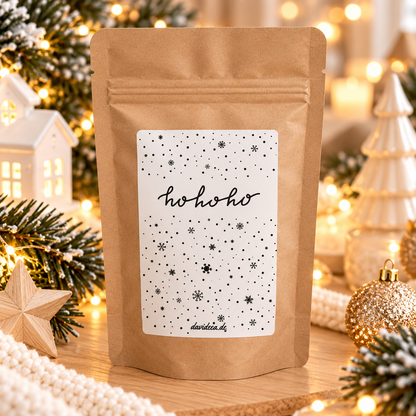 Weihnachtliche Geschenktüte aus braunem Kraftpapier mit weißem Sternenetikett und schwarzem „ho ho ho“-Schriftzug für Kaffee