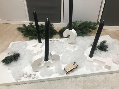Minimalistischer Adventskranz aus Raysin mit weißen Zahlen und schwarzen Stabkerzen auf weißem Untergrund, ohne Kerzen und Deko geliefert.