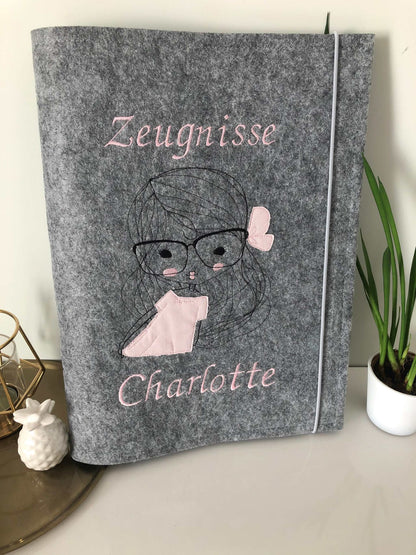 Graue Filz-Zeugnismappe DIN A4 mit Namensstickerei und floralem Design.