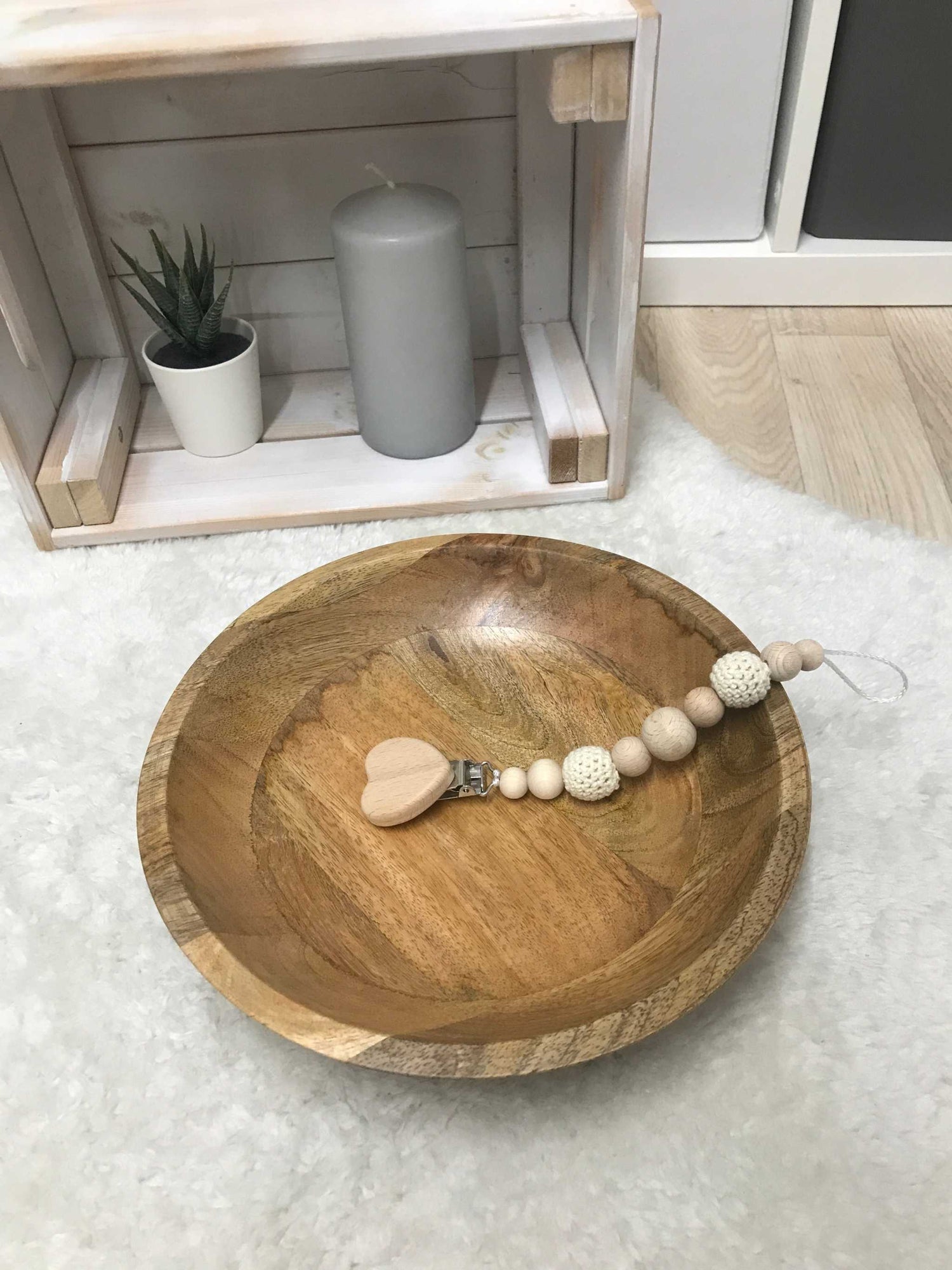Pacifier chain with wooden and crochet beads in wooden bowl.