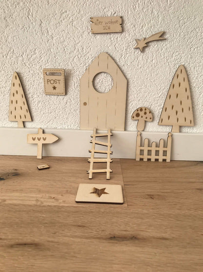Holz-Wichteltür mit Zubehör, Weihnachtsdekoration auf Holzfußboden.