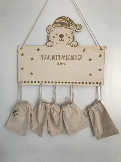 Personalisierbarer Adventskalender aus Holz mit Jutesäckchen, nachhaltige Weihnachtsdekoration.