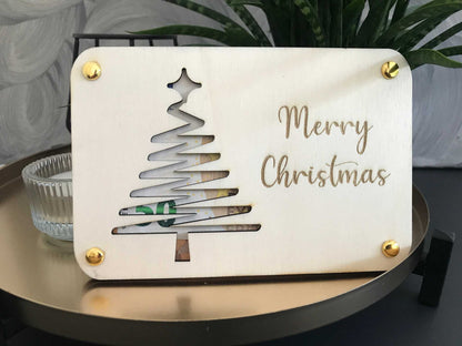 Weihnachtliche Geldkarte mit Tannenbaum-Ausschnitt und "Merry Christmas" Gravur, stilvoll für Geldgeschenke.
