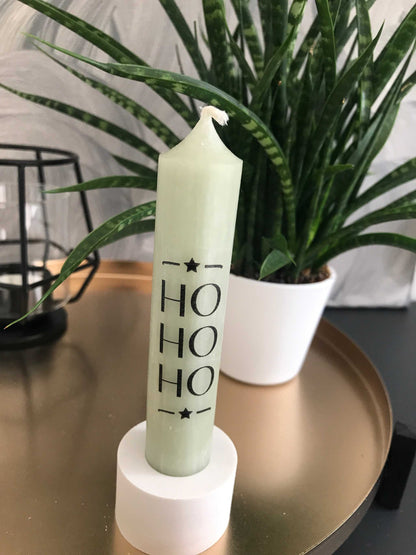 Festliche grüne Stabkerze mit "HO HO HO" Design für Weihnachten, elegante Dekoration.
