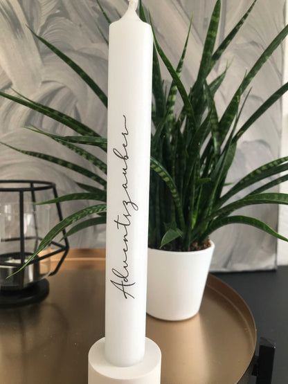 Kerzen für Weihnachten als elegante Dekoration auf goldenem Tisch mit grüner Pflanze im Hintergrund.
