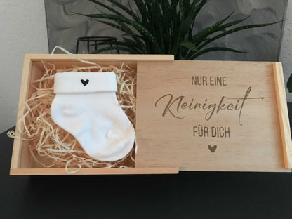 Holzbox zur Schwangerschaftsankündigung mit Babysöckchen und Herzmotiv.