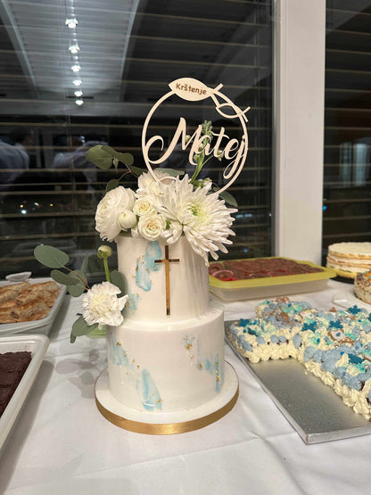 Caketopper für Taufe auf dekorierter Torte mit Blumen und Kreuz.