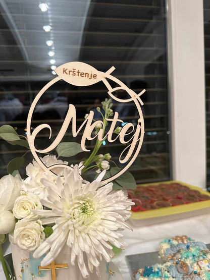 Caketopper aus Pappelsperrholz für Taufe, personalisiert, ø 15 cm, Blumenarrangement im Hintergrund.