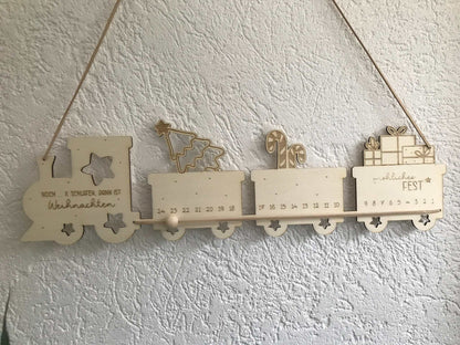 Personalisierter Holz-Adventskalender in Zugform, nachhaltige Weihnachtsdekoration.