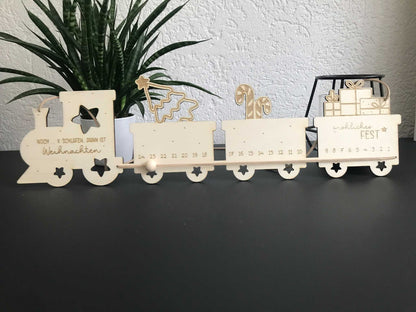 Holz Adventskalender in Zugform mit Zahlen und weihnachtlichen Motiven auf schwarzem Hintergrund.