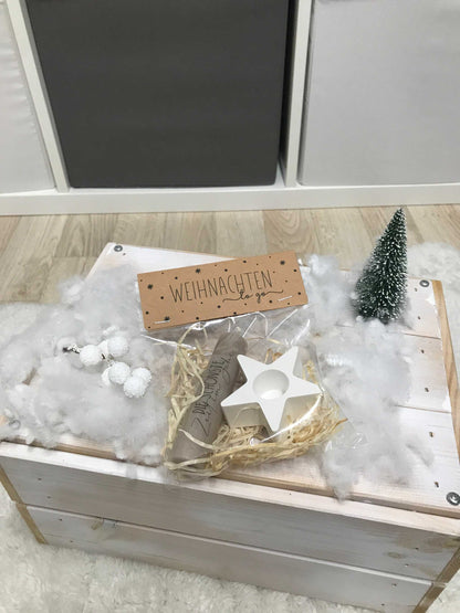 Weihnachtsgeschenkset mit Kerze und Dekoration, inklusive Kerzenständer in Sternform aus Keramik, auf Holzbox präsentiert.