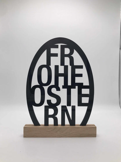Osterdekoration aus Acryl mit "Frohe Ostern" Schriftzug und Holzklötzchen.