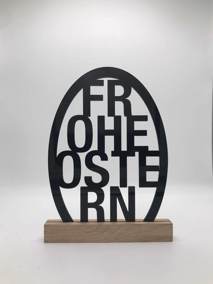 Osterdekoration mit "Frohe Ostern" Schriftzug aus Acryl und Holzklötzchen.
