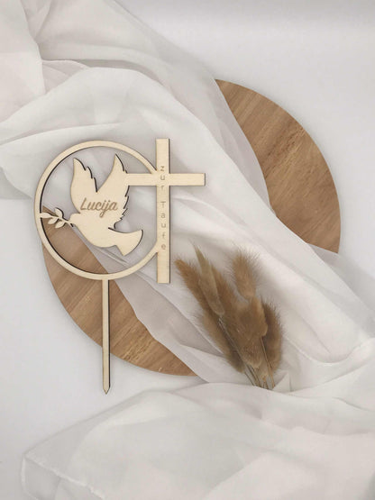 Caketopper for Baptism with dove and cross design on white fabric background.