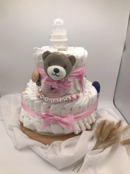 Windeltorte mit Schnullerkette als Geschenkidee für werdende Eltern, handgefertigt mit Windeln, Kuscheltier und Babyaccessoires.