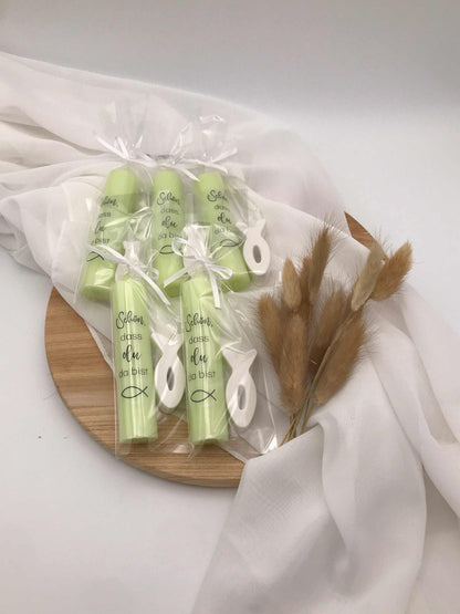 Gastgeschenke zur Taufe mit personalisierten Kerzen und symbolischen Fischen auf Holztablett.