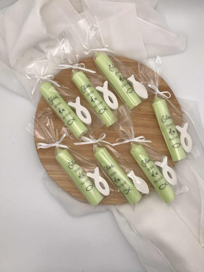 Grüne Kerzen mit symbolischen Fischanhängern als Gastgeschenke zur Taufe oder Kommunion auf Holztablett.