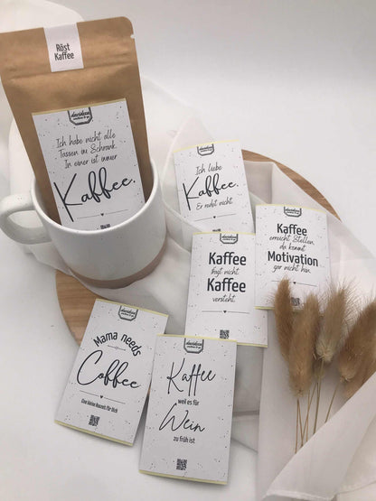 Keramiktasse mit Spruch "Mama ist die Beste" und Kaffee-Geschenkset, auf Holzbrett arrangiert.