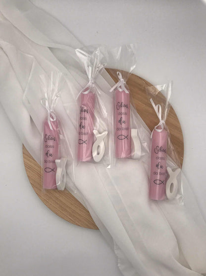 Gastgeschenke zur Taufe: Rosa Kerzen mit Fischsymbol, verpackt in Folie und personalisiert für besondere Anlässe.
