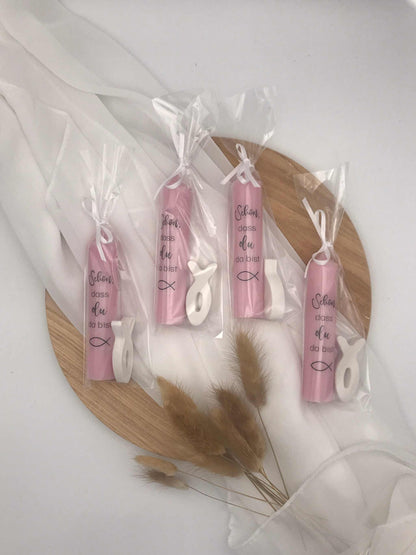Gastgeschenke zur Taufe, Kommunion, Firmung; pinke Kerzen mit Fischsymbol in durchsichtiger Verpackung auf Holzteller.
