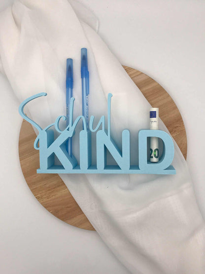 Personalisierter Tischaufsteller "Schulkind" in Blau mit Reagenzglas für Stifte und Geldgeschenk zur Einschulung auf Holzunterlage.