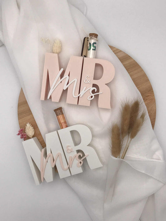Modern 3D-printed "Mrs & Mrs" wedding gift with test tube for money or messages on decorative background.