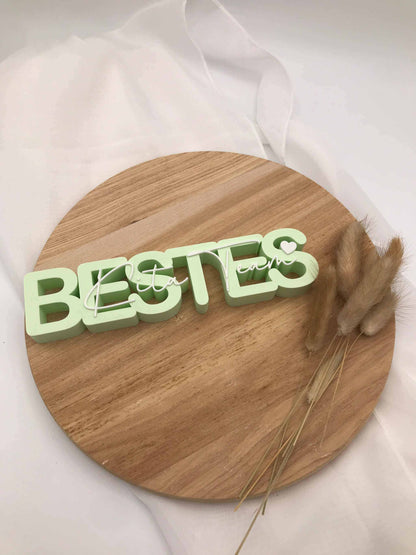 3D-Druck Aufsteller „Bestes Kita-Team“ als Abschiedsgeschenk für Kindergarten Erzieher:innen auf Holzuntergrund.