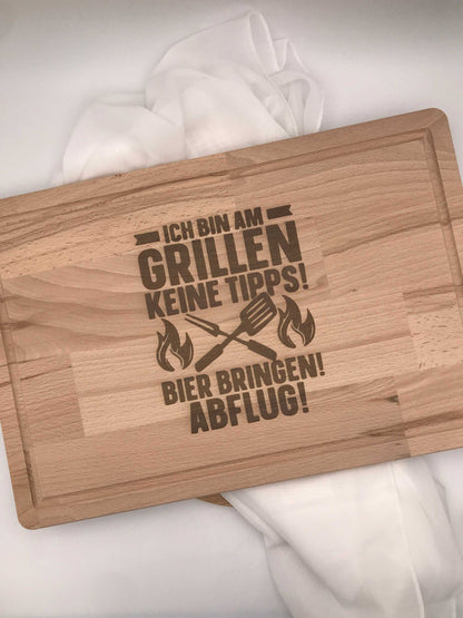 Holz-Schneidebrett mit Gravur "Ich bin am Grillen" auf weißem Hintergrund.